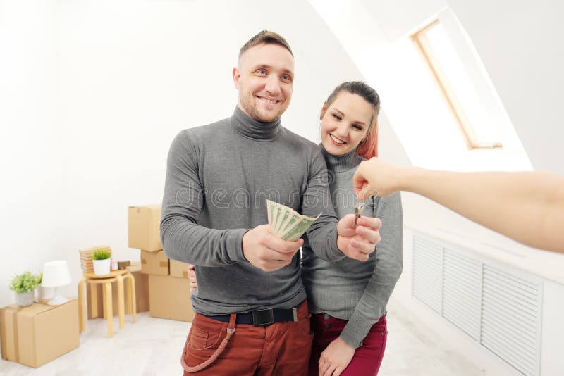 El vendedor da a clientes las llaves al nuevo apartamento imagen de archivo libre de regalías El vendedor da a clientes las llaves al nuevo apartamento imagen de archivo libre de regalías