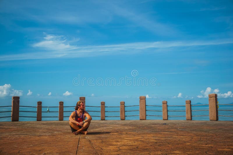 El viajero se sienta en la costa fotografía de archivo libre de regalías El viajero se sienta en la costa fotografía de archivo libre de regalías