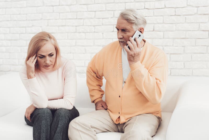 El viejo hombre cerca trastornó a la mujer mayor que hablaba en Smartphone imagen de archivo libre de regalías
