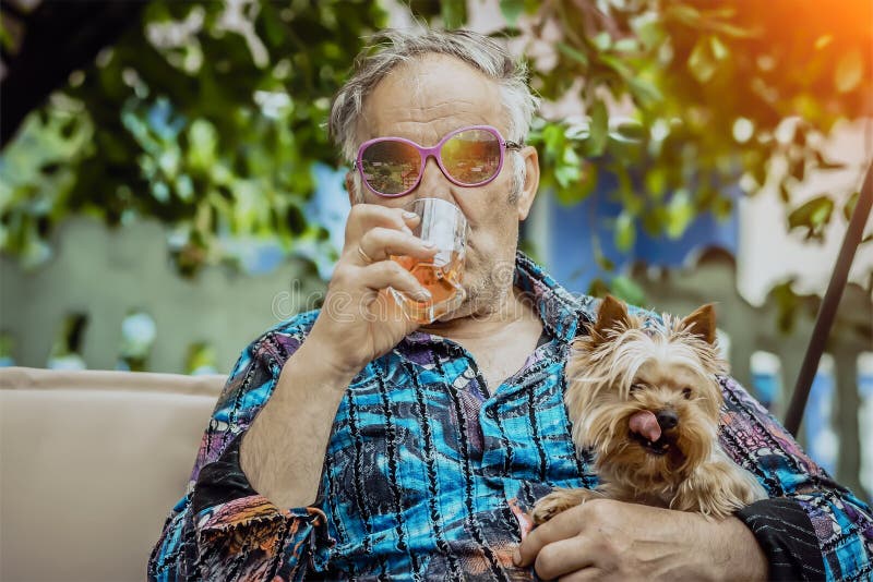 El viejo hombre con un perro disfruta de vida foto de archivo El viejo hombre con un perro disfruta de vida foto de archivo