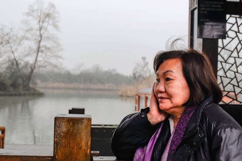 El viejo viajero asiático hermoso de las mujeres muy se relaja y tranquilo en el parque de ciudad de Hangzhou fotos de archivo El viejo viajero asiático hermoso de las mujeres muy se relaja y tranquilo en el parque de ciudad de Hangzhou fotos de archivo