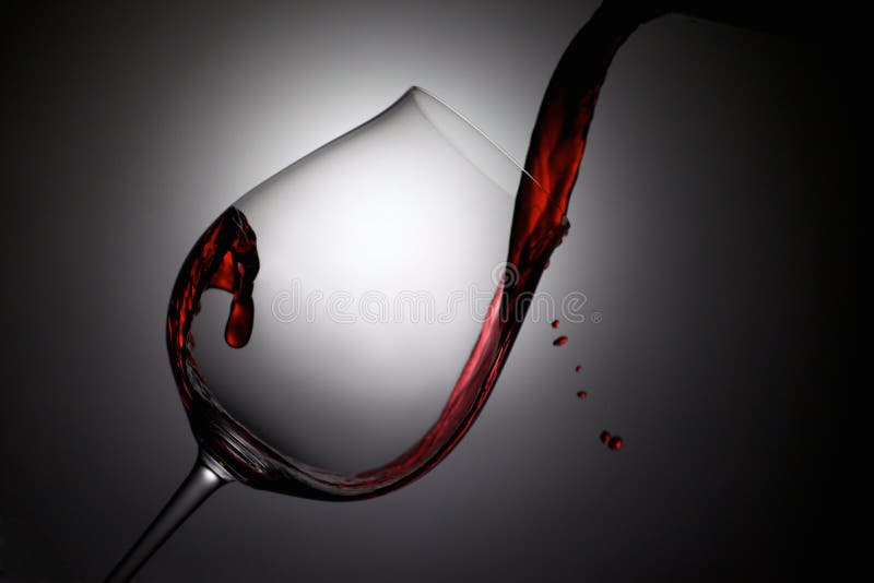 El vino rojo vertió en una copa de vino con descensos imagen de archivo libre de regalías El vino rojo vertió en una copa de vino con descensos imagen de archivo libre de regalías