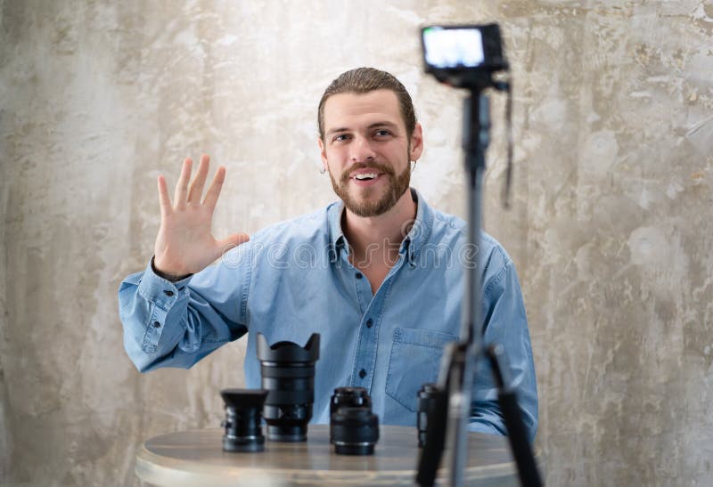 El vlogger joven del inconformista est? mostrando la colecci?n de lente de c?mara mientras que bloguean los consejos de registrac imagen de archivo libre de regalías El vlogger joven del inconformista est? mostrando la colecci?n de lente de c?mara mientras que bloguean los consejos de registrac imagen de archivo libre de regalías