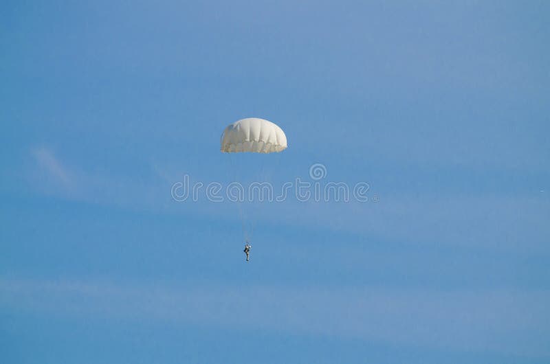 El vuelo del paracaidista en un cielo azul foto de archivo El vuelo del paracaidista en un cielo azul foto de archivo