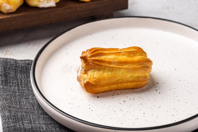 Elair francés con crema. Profiteroles con crema en placa blanca. imágenes de archivo libres de regalías