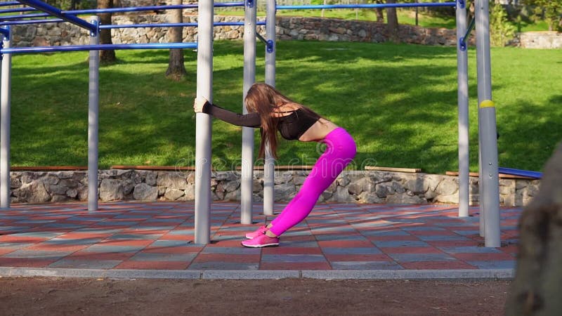 Elastyczna młoda kobieta rozciąga out przy piękny pogodnym po tym jak długa wymagająca działająca sesja w zielonym miasto parku