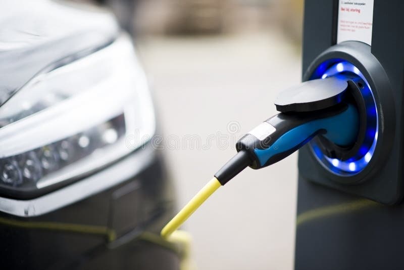 Electric car charging in a public area, partial view of the car. Electric car charging in a public area, partial view of the car