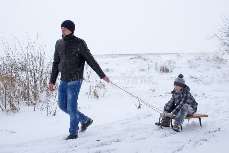 The elder brother on sleds pulls sled the younger brother. The elder brother on sleds pulls sled the younger brother