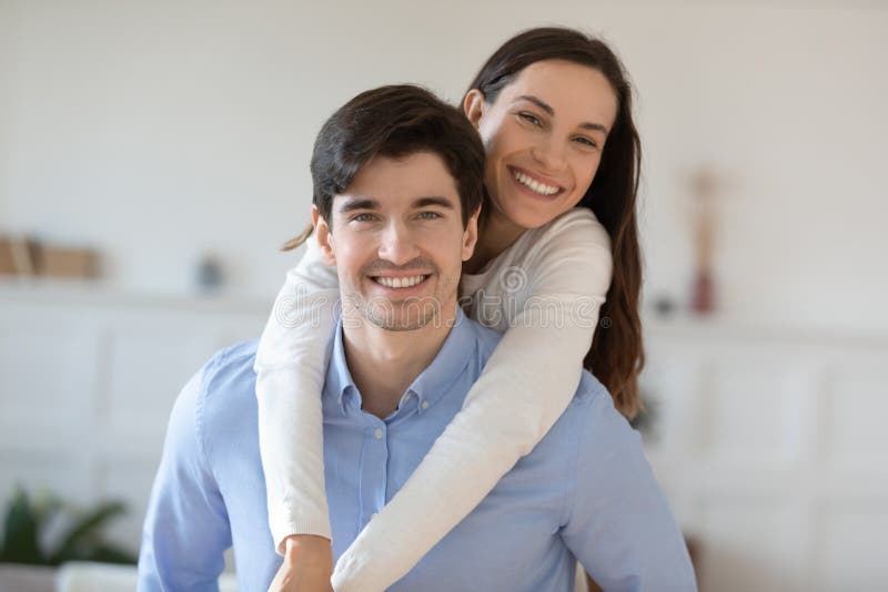 Elder brother student piggybacking teenage sister posing for cute picture