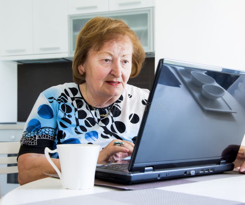 Elder woman with a computer stock image Elder woman with a computer stock image