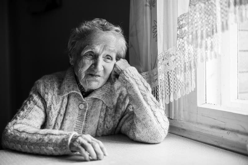 Elderly alone woman portrait contrast of black and white.