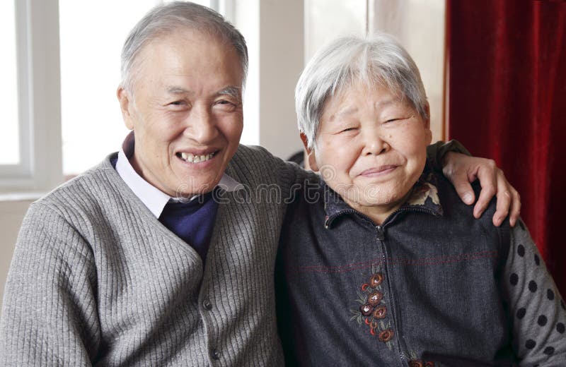 Senior people gadgets in room. Happy elderly couple on sofa in