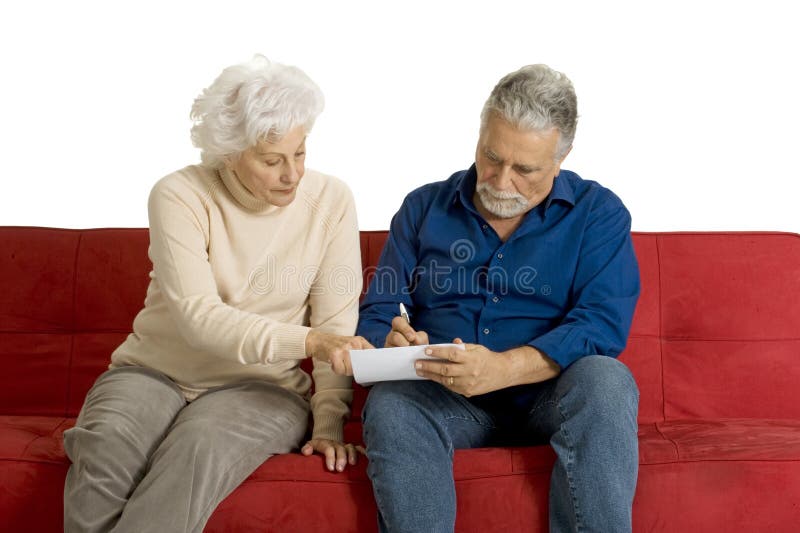 Elderly couple on the couch writing i