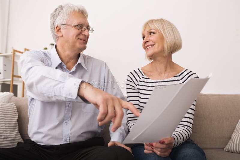 Elderly couple discussing documents, looking at each other stock photos Elderly couple discussing documents, looking at each other stock photos