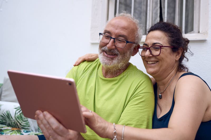 An Elderly Couple Making a Video Call with a Tablet Stock Photo Image
