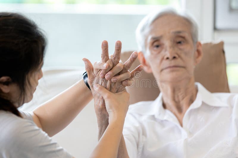 Elderly female patient suffer from numbing pain in hand,arthritis,tendon inflammation,stiffness of the joints,asian senior women get a palm finger massage to treat beriberi,numbness fingertip concept. Elderly female patient suffer from numbing pain in hand,arthritis,tendon inflammation,stiffness of the joints,asian senior women get a palm finger massage to treat beriberi,numbness fingertip concept