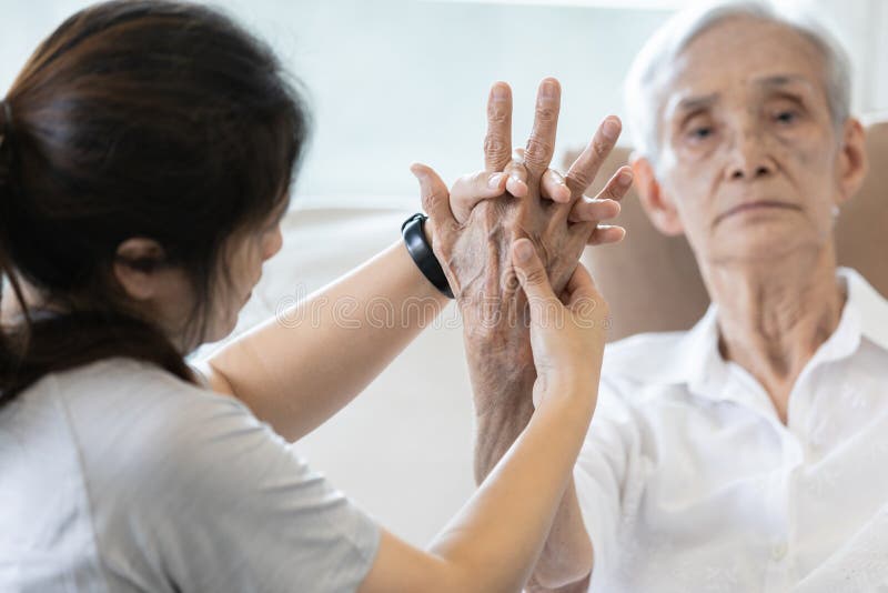 Elderly female patient suffer from numbing pain in hand,arthritis,tendon inflammation,stiffness of the joints,asian senior women get a palm finger massage to treat beriberi,numbness fingertip concept. Elderly female patient suffer from numbing pain in hand,arthritis,tendon inflammation,stiffness of the joints,asian senior women get a palm finger massage to treat beriberi,numbness fingertip concept