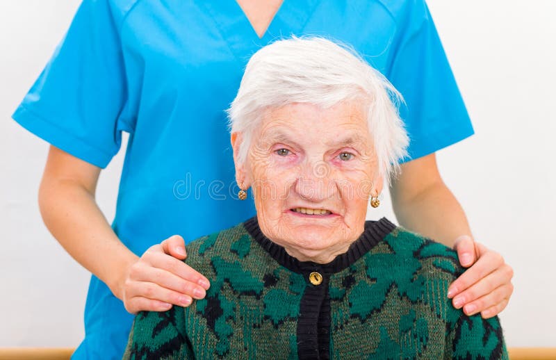 Photo of elderly woman supported by young doctor. Photo of elderly woman supported by young doctor