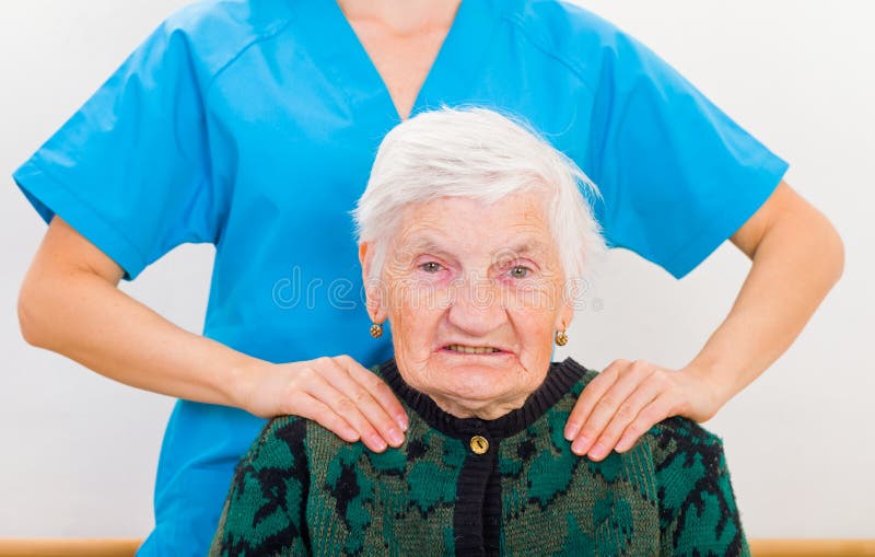 Photo of elderly woman supported by young doctor. Photo of elderly woman supported by young doctor