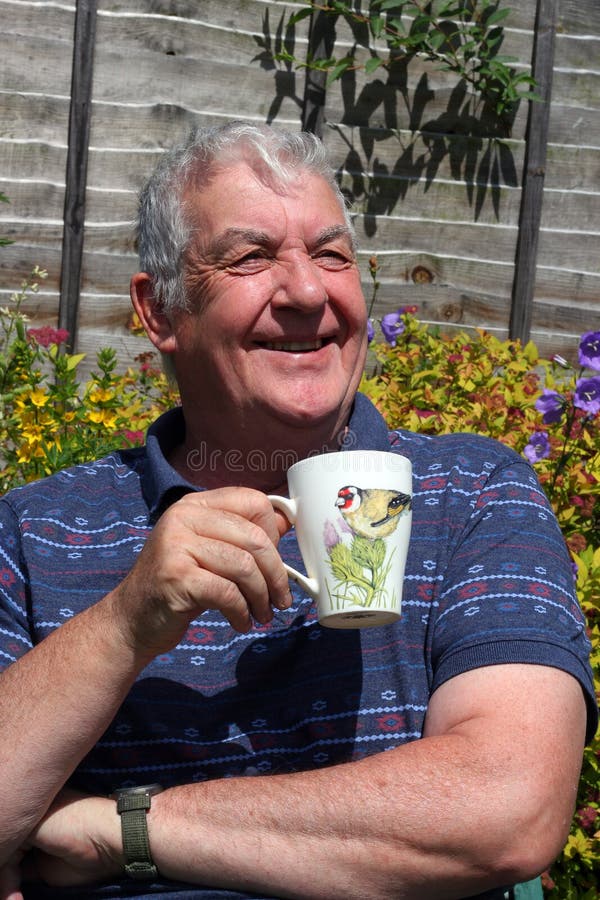 Elderly man close up drinking coffee outside.