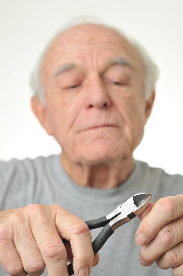 Elderly man cuts his fingernail with plyers