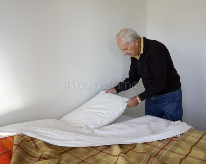 Elderly Man Making His Bed. Stock Photo Image of senior, indoors