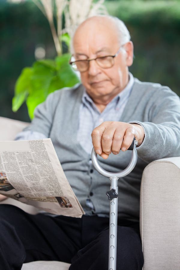 Elderly Man Reading Newspaper At Nursing Home stock photo Elderly Man Reading Newspaper At Nursing Home stock photo