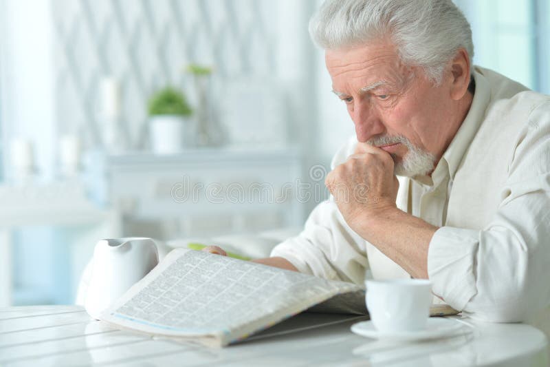 Elderly man reading a newspaper