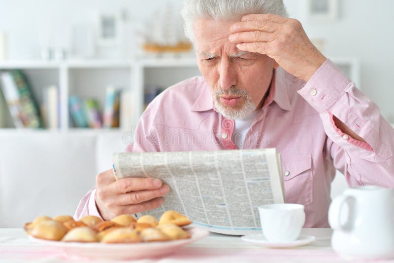 Elderly man reads a newspaper