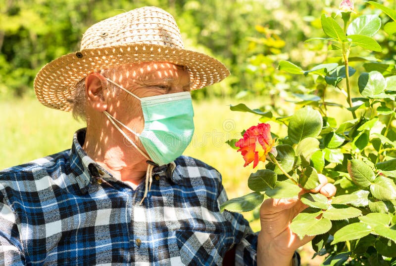 Elderly man wearing a protective mask in the domestic quarantine period in the garden.