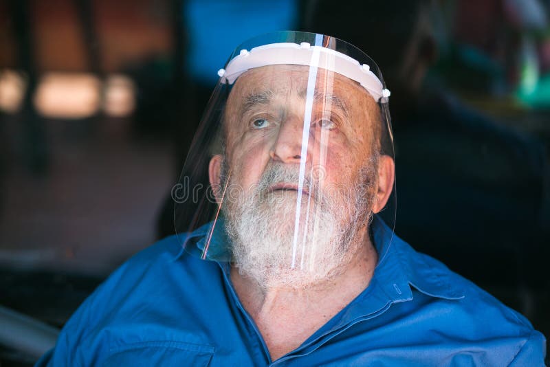 Senior Man Wearing a Protective Visor and Santa Claus Suit Stock Photo
