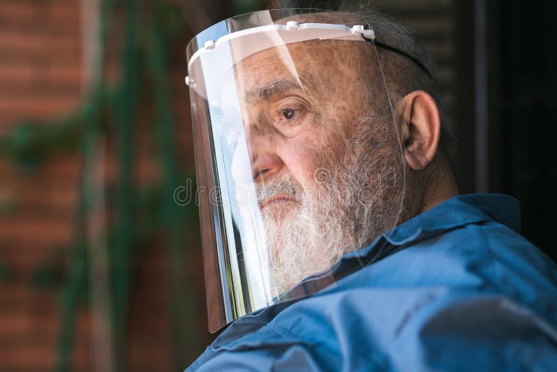 Senior Man Wearing a Protective Visor and Santa Claus Suit Stock Image