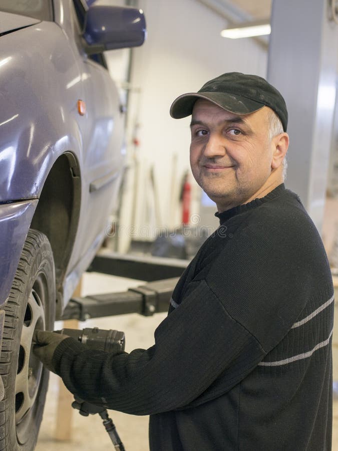 Elderly mechanic fixing old car royalty free stock images