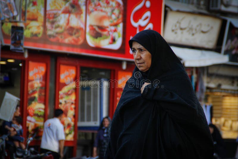 Elderly Muslim Arab Woman in Black Nikab and Abaya with a Handbag