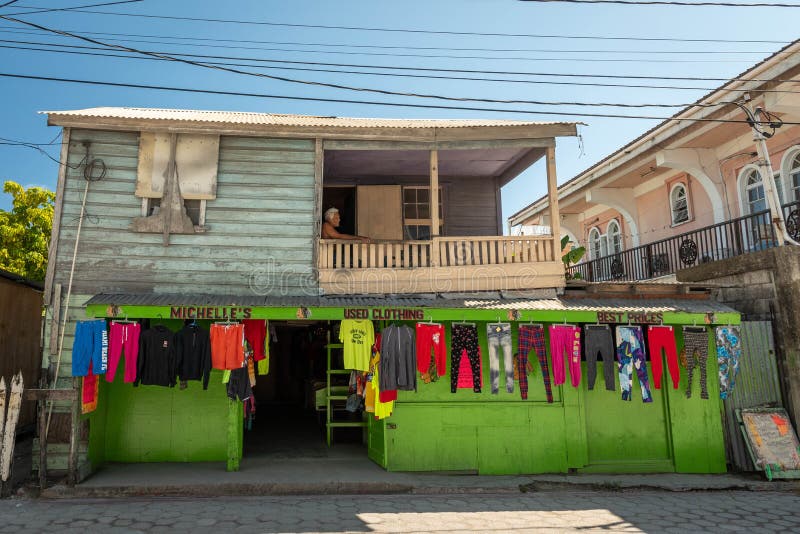 An elderly shirtless Belizean man resting on the balcony