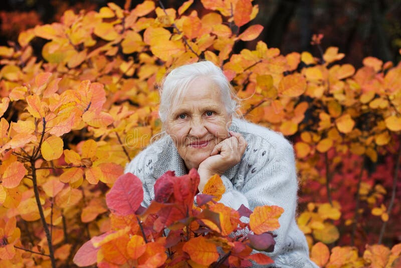 Elderly woman at the autumn background