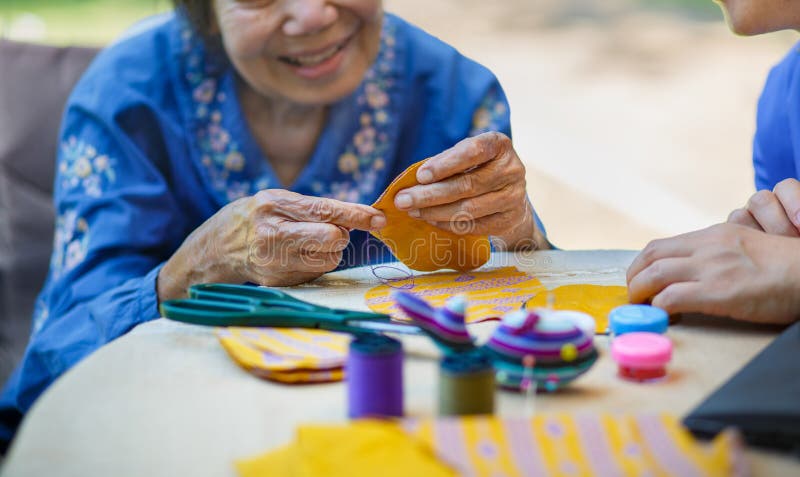 Elderly woman with caregiver in the needle crafts occupational therapy  for AlzheimerÃ¢â¬â¢s or dementia