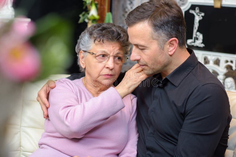 Elderly woman comforting young man royalty free stock photography