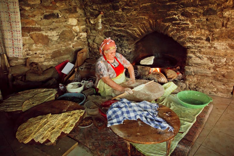 Elderly woman cooking traditional Gozleme dish rustic stone oven of old turkish village stock image Elderly woman cooking traditional Gozleme dish rustic stone oven of old turkish village stock image