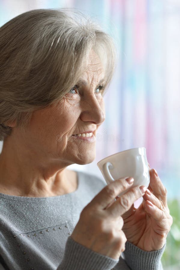 Elderly woman with cup of coffee