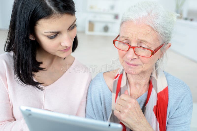 Elderly woman and daughter reading their tablet royalty free stock photo Elderly woman and daughter reading their tablet royalty free stock photo