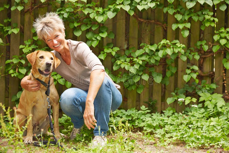 Elderly woman with dog in a garden