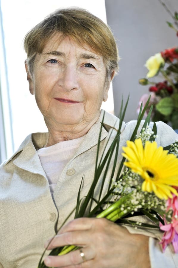 Elderly woman with flowers stock photography Elderly woman with flowers stock photography