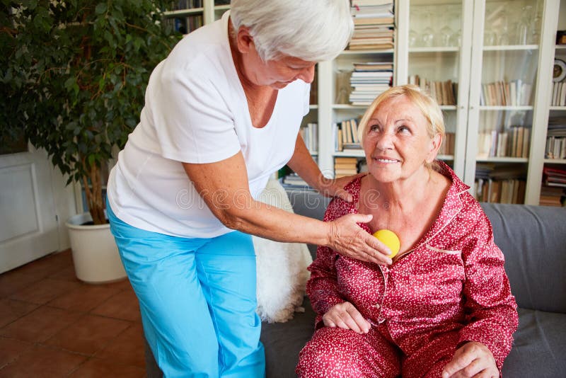 Elderly women receives a trigger point massage as acupressure with a small massage ball. Elderly women receives a trigger point massage as acupressure with a small massage ball