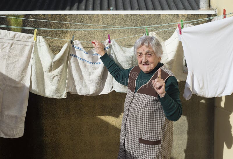 elderly-woman-hanging-out-washing-terrac