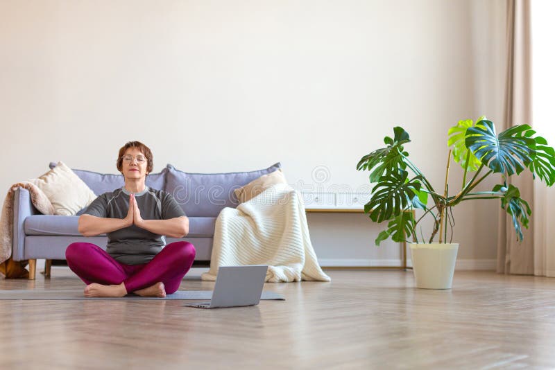 Young woman doing online yoga at home. Online fitness, home workout. - a  Royalty Free Stock Photo from Photocase