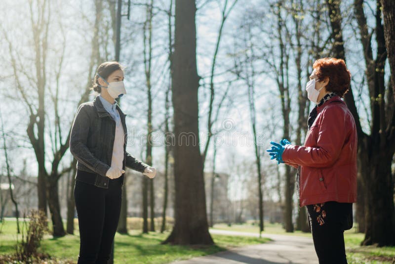 Elderly woman with protective face mask/gloves talking with a friend.Coronavirus COVID-19 disease protection.Conversation from a