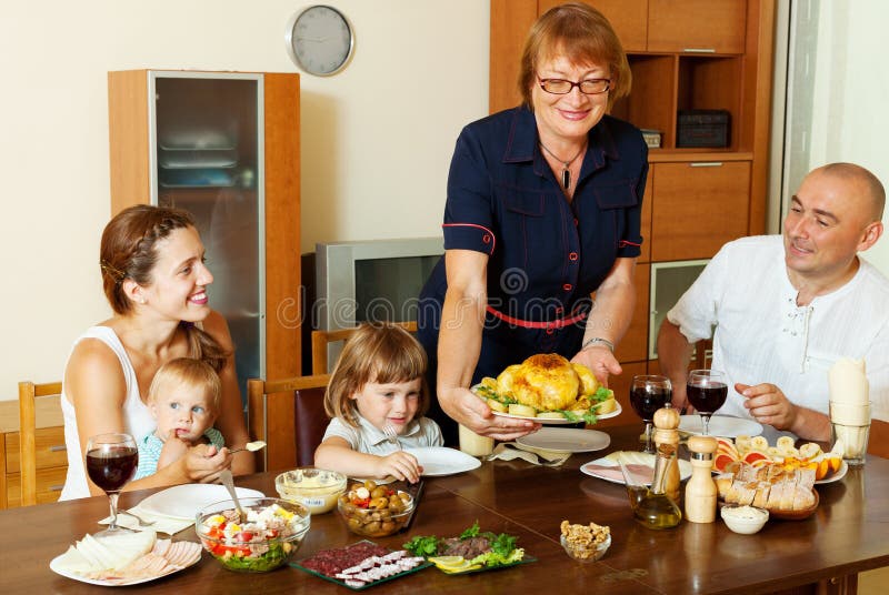 Elderly woman serving baked chicken to table royalty free stock image Elderly woman serving baked chicken to table royalty free stock image