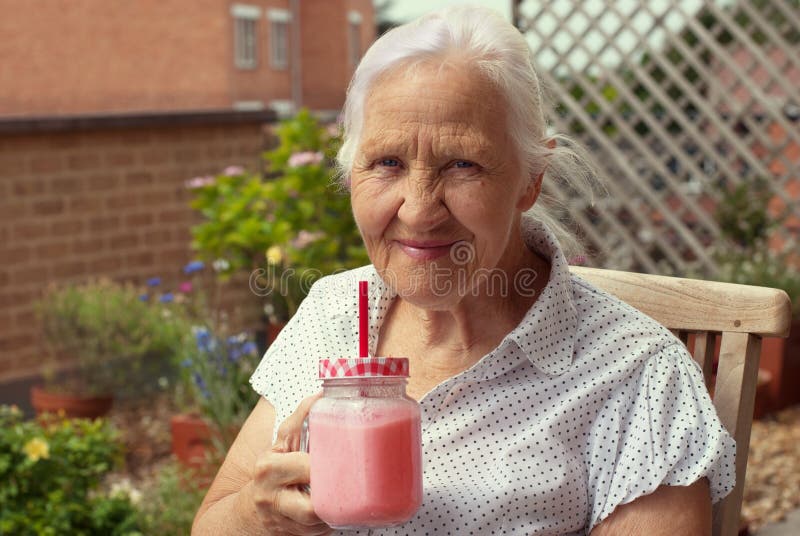 Elderly woman with smoothie stock photography Elderly woman with smoothie stock photography
