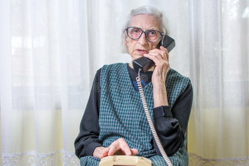 Elderly woman using the phone indoors